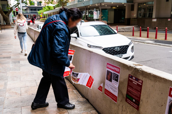 A North Sydney Council employee removing Kidnapped posters in North Sydney on Friday.