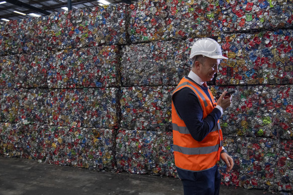 Matt Kean, the Energy and Environment Minister, stands in front of bales of aluminium cans - about 10,000 in each - that will be recycled.