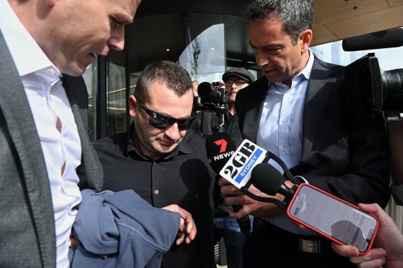 Anthony Koletti (centre), the husband of Melissa Caddick, leaves the Coroners Court.