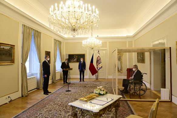 Czech President Milos Zeman, right, in a transparent cube, appoints ODS leader Petr Fiala, left, as Czech Prime Minister at the Lany manor, near Prague.