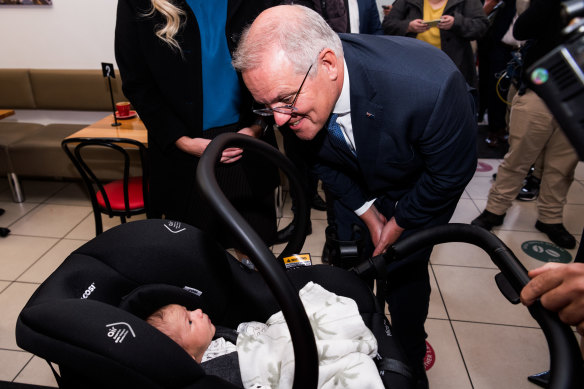 Prime Minister Scott Morrison greets a baby at cafe Cibo Espresso, in Glenelg, South Australia, in the seat of Boothby. 