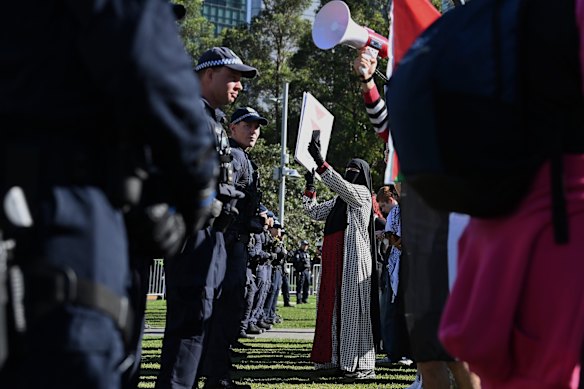 People protest at Tumbalong Park against defence companies outside the Indo-Pacific 2025 International Maritime Exposition held at the International Convention Centre in Darling Park, NSW. 