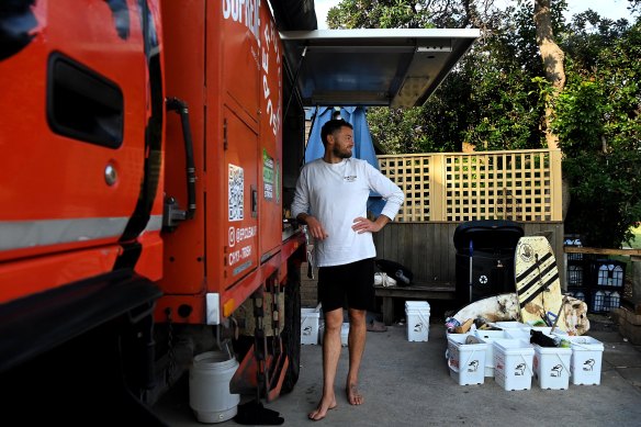 Roland Davies dispenses free coffees from a barista machine installed in an old fire truck to beachgoers who collect a bucket of rubbish.
