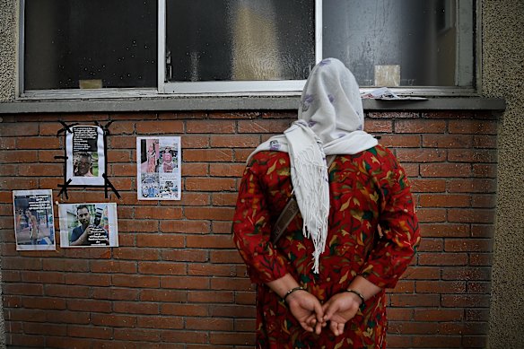 A woman outside the TU Teaching Hospital in Kathmandu looks at posters of people reported missing after the Nepal flood disaster.