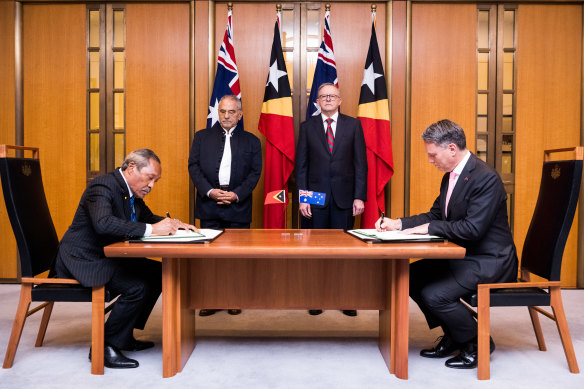 East Timor Defence Minister Filomeno da Paixão de Jesus (left) and Defence Minister Richard Marles sign the agreement, as East Timor President José Ramos-Horta and Prime Minister Anthony Albanese look on.