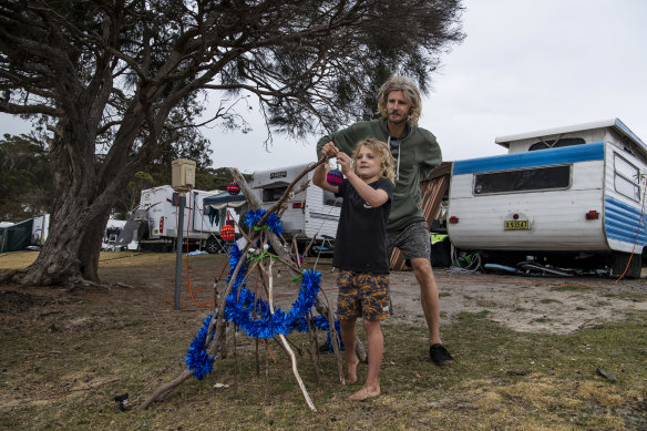 Seven-year-old Miller Forrester makes a Christmas tree out of driftwood at Merry Beach caravan park. 