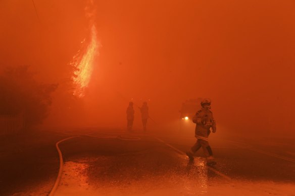 The blaze overwhelms firefighters on the ground.