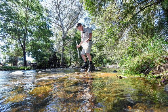 Rod Falconer testing the water where the creek runs through his property.