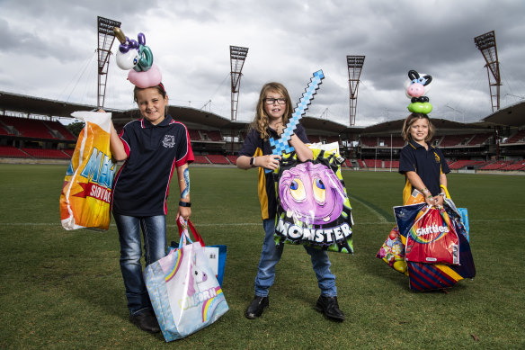 Pony Club members Abbie, 9, Sophie, 11, and Lilah, 7, hold the showbags they have help inspect.