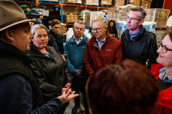 Prime Minister Anthony Albanese and NSW Premier Dominic Perrottet talk to flood victims at a community pantry.