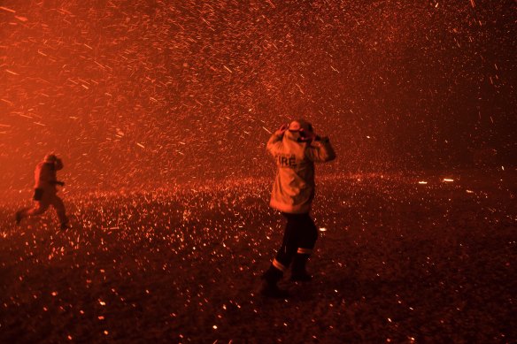 Firefighters run for safety as the Green Wattle Creek fire exploded from the bush in Orangeville on December 5. 