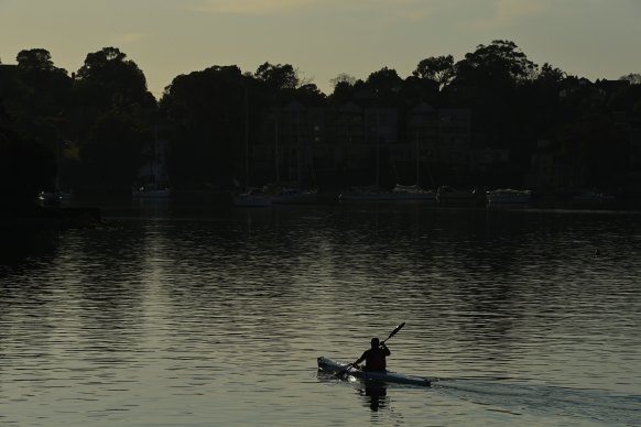 A man kayaks on the Paramatta River past Meditation Park at Looking Glass Point in Gladesville, before the storm is due to hit. 