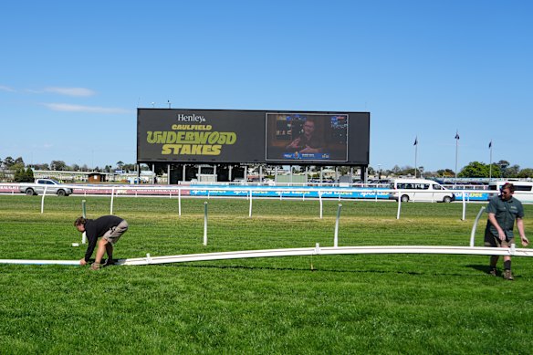 The Caulfield rail is moved before the first race on Saturday because of track safety concerns.