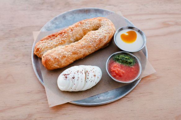 Ziva, a fat pastry filled with cheese and olives, and served with boiled eggs, tahini, pickles and crushed tomatoes.