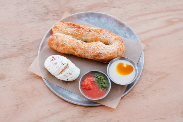 Ziva, a fat pastry filled with cheese and olives, and served with boiled eggs, tahini, pickles and crushed tomatoes.