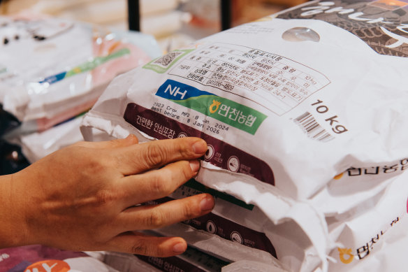 Daero Lee points out the harvest date on a bag of rice.