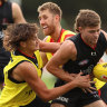 MELBOURNE, AUSTRALIA - MAY 19: Brayden Ham of the Bombers is challenged by Tex Wanganeen and Dyson Heppell during an Essendon Bombers AFL training session at The Hangar on May 19, 2022 in Melbourne, Australia. (Photo by Robert Cianflone/Getty Images)