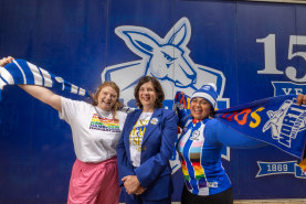 Mega fans Caitlin Latter (left) and Devina Potter with North Melbourne president Sonja Hood.