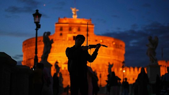 A street musician plays a violin outside the Sant’Angelo castle as the sun sets in Rome on Sunday.