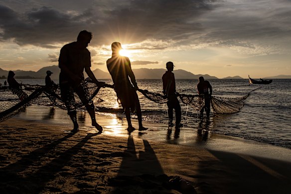 A group of fishermen pull fishing nets at Gampong Jawa beach ahead the twenty-year anniversary of the 2004 earthquake and tsunami in Banda Aceh.