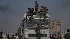 Palestinians carry sacks of flour unloaded from a humanitarian aid convoy that reached Gaza City from the northern Gaza Strip, Sunday, July 27, 2025.