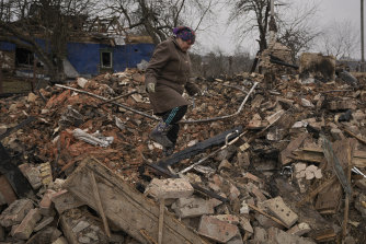 O femeie caută bunuri personale sub dărâmăturile casei ei, care au fost distruse în timpul luptelor din satul Yasnohorodka, la periferia Kievului.