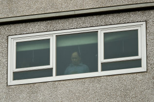 A resident looks out their window while under lockdown in a North Melbourne housing tower on Sunday.