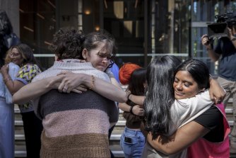 Young climate activists including Luca Saunders (left) and Natasha Abhayawickrama hug friends outside court after Tuesday’s decision.