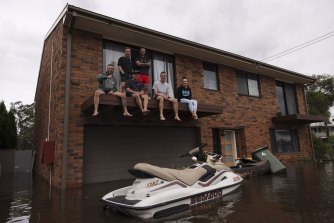 Matt Elgood (wearing a green jumper) and friends on the second storey of his home in Pitt Town. 