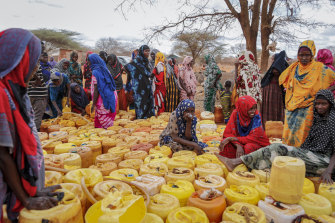 Kenyan women of Somali origin wait with their containers for a water distribution from the government near Kuruti, in Garissa County, Kenya.
