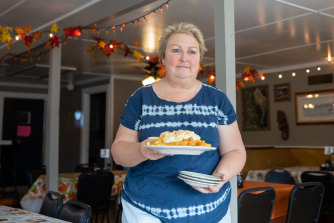 Jamie Parks brings a plate of “crabby fries” to a table at Lorraine’s Seafood Restaurant.