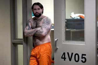 Erik Eck, a former member of the Latin Kings gang stands in the doorway of his cell at the DuPage County jail displaying tattoos that symbolise his status with the gang.