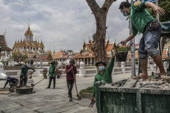 People repair pavement near the Grand Palace in Bangkok, the capital of Thailand. Some people prefer their leaders focus on fixing the economy rather than on changing the city’s name.