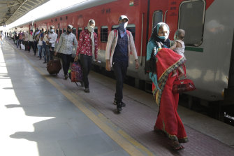 Migrant workers walk to board a special train to return to Agra in Uttar Pradesh state, during a nationwide lockdown.