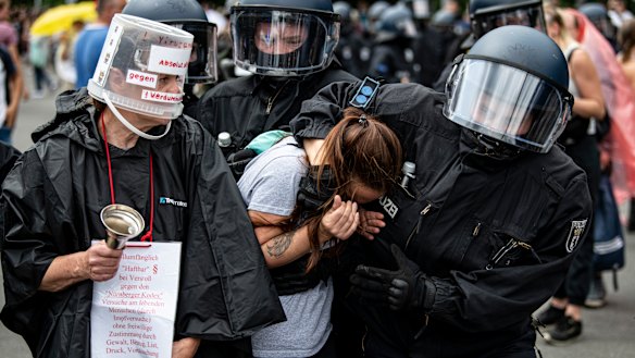 Police arrest a demonstrator at an unannounced demonstration at the Victory Column, in Berlin.