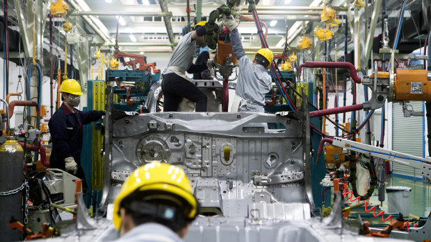 Workers assemble a vehicle at the Xiaopeng Motors prototype centre in China.