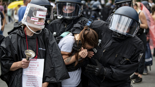 Police arrest a demonstrator at an unannounced demonstration at the Victory Column, in Berlin.