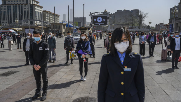 Commuters at Beijing Railway Station observe the three minutes of silence. 