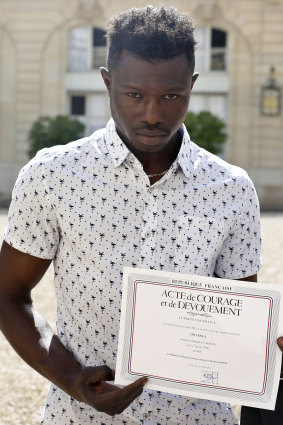 Gassama with a certificate of courage and dedication.
