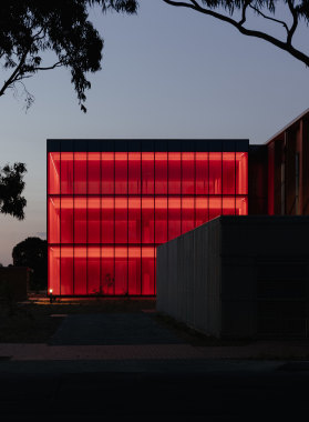 The extruded glass box illuminates at night: flashing red for Anzac Day, hi-vis orange in tribute to SES volunteers during the fires and blue for recently fallen police officers. 