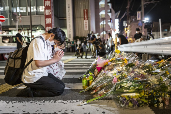 People pray at a site outside of Yamato-Saidaiji Station where Japan’s former prime minister Shinzo Abe was shot on July 8, 2022, in Nara. 