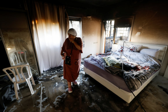 A woman stands in a damaged room in Ashkelon, Israel, after rockets were launched from the Gaza Strip.