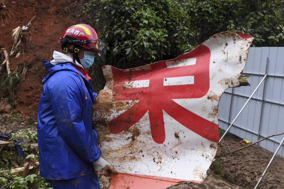 A rescue team member carries a piece of debris at the China Eastern flight crash site in Tengxian County in southern China’s Guangxi Zhuang Autonomous Region.