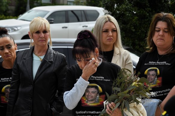 A grandmother of Nathan Reynolds, Toni Reynolds (3rd from left) wipes tears from her eyes during a statement on Nathan’s death in custody in 2018.
