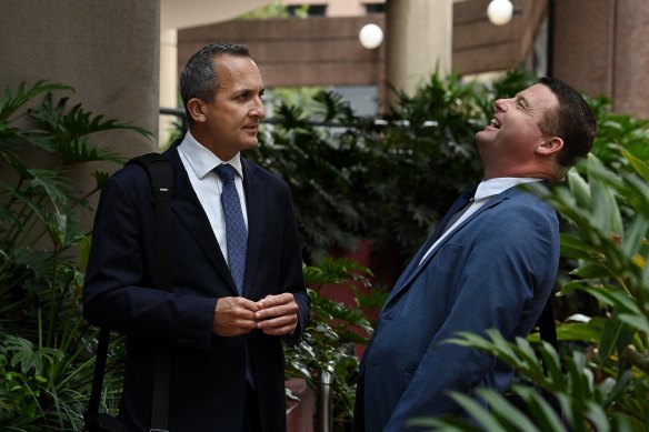 NRL chief executive Andrew Abdo and South Sydney’s Blake Solly share a laugh outside Racing NSW’s headquarters.