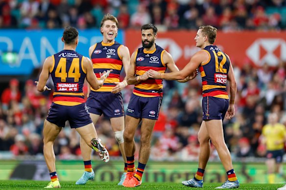 Crows players surround Wayne Milera after he kicked a goal in his team’s 90-point thumping of Sydney.