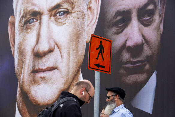 Pedestrians pass an election campaign billboard with photos of Benny Gantz, left, and Benjamin Netanyahu in Ramat Gan, Israel.