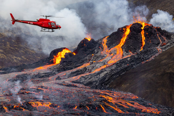 A helicopter flies close to a volcanic eruption which has begun in Fagradalsfjall near the capital Reykjavik on March 20, 2021 in Fagradalsfjall, Iceland.