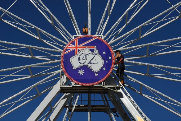 Wheel of Oz ride operators carries out a safety check on the ferris wheel, which was installed on the beach for the postponed Bondi Festival. 