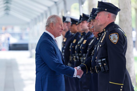 King Charles shakes hands with a police officer at the 9/11 memorial.